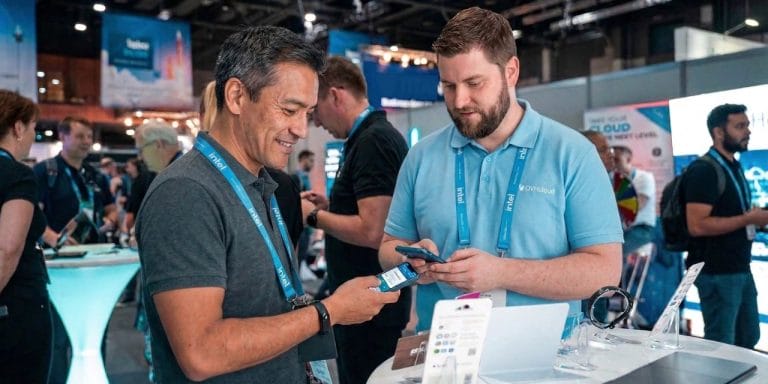 Two men exchanging digital business cards at a conference